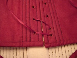 Once you have laced down the garment, thread the cord back through the opposite eyelet.